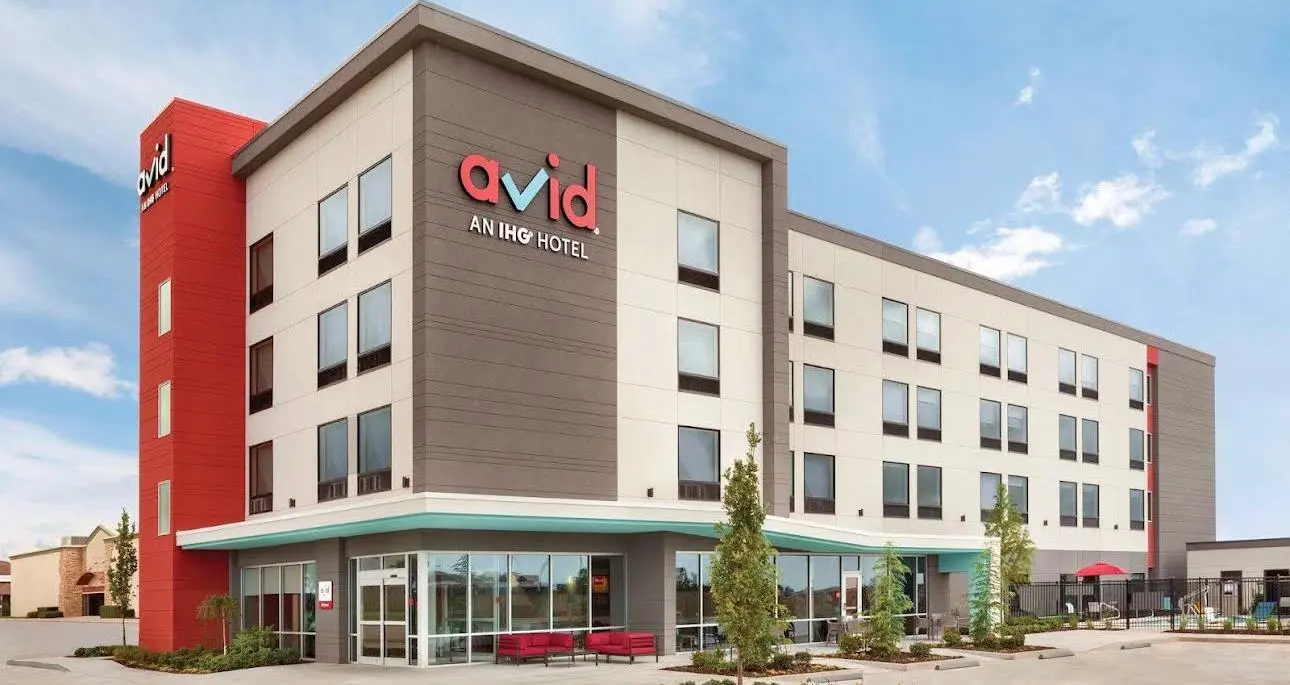An avid hotel, an IHG hotel, in grey and red with a glazed ground floor